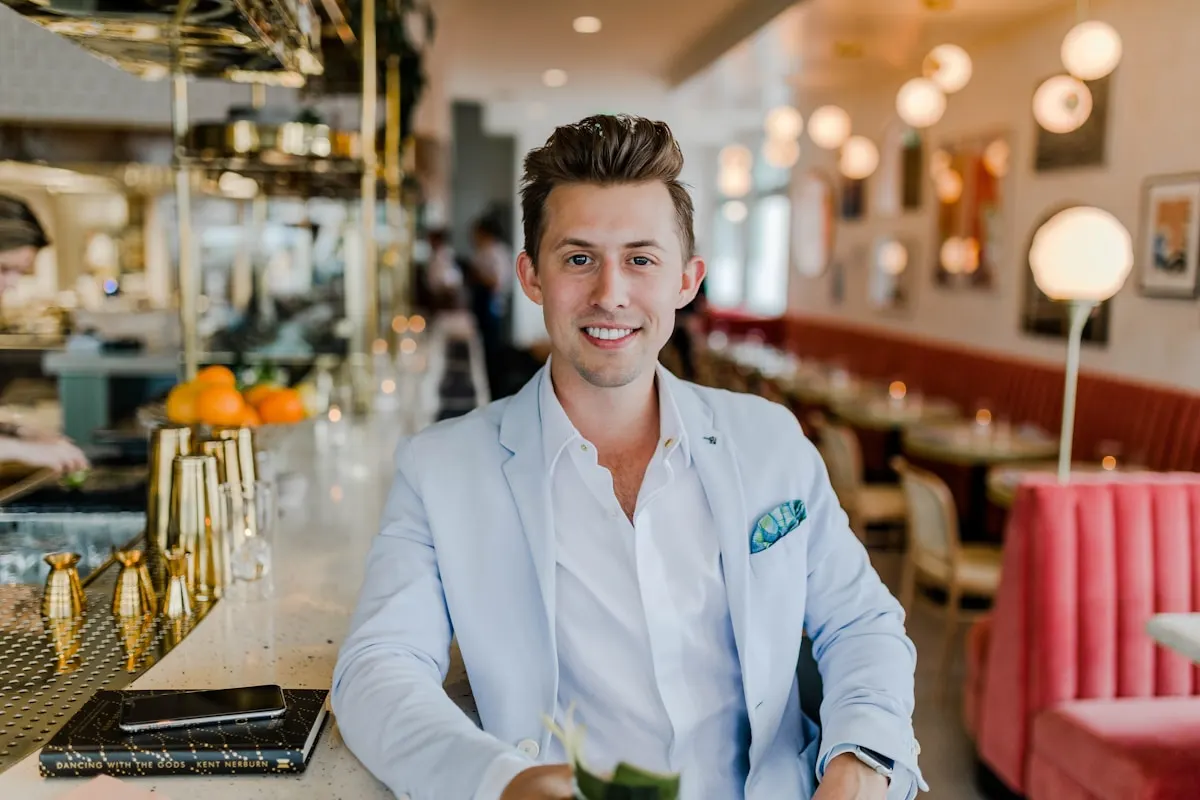 A man in a light blazer sitting at a restaurant bar